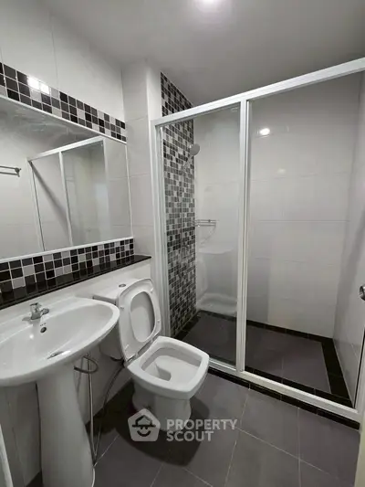 Modern bathroom with sleek shower and stylish black and white tiles