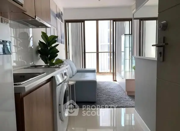 Modern apartment interior with washing machine and cozy living area.