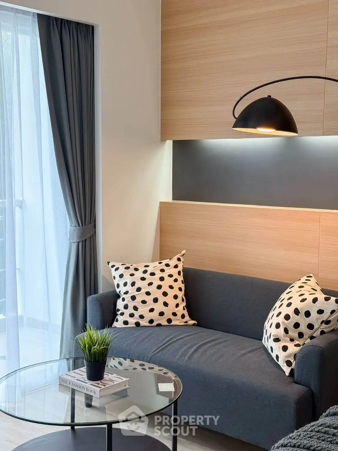 Modern living room with stylish sofa, polka dot cushions, and elegant lighting