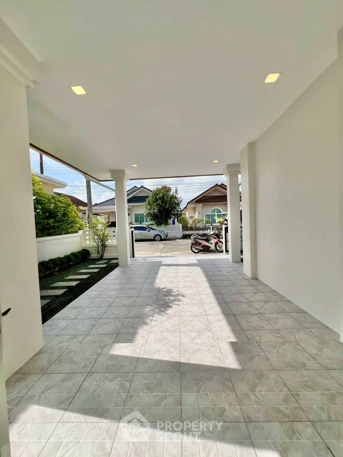Spacious covered entrance with tiled flooring and garden view in modern home