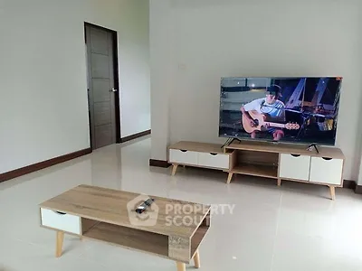 Modern living room with sleek furniture and flat-screen TV, perfect for relaxation and entertainment.