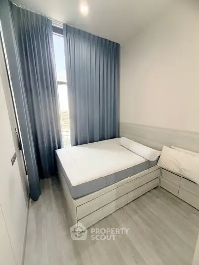 Modern minimalist bedroom with large window and stylish curtains