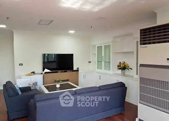 Spacious living room with modern furniture and large TV, perfect for relaxation.