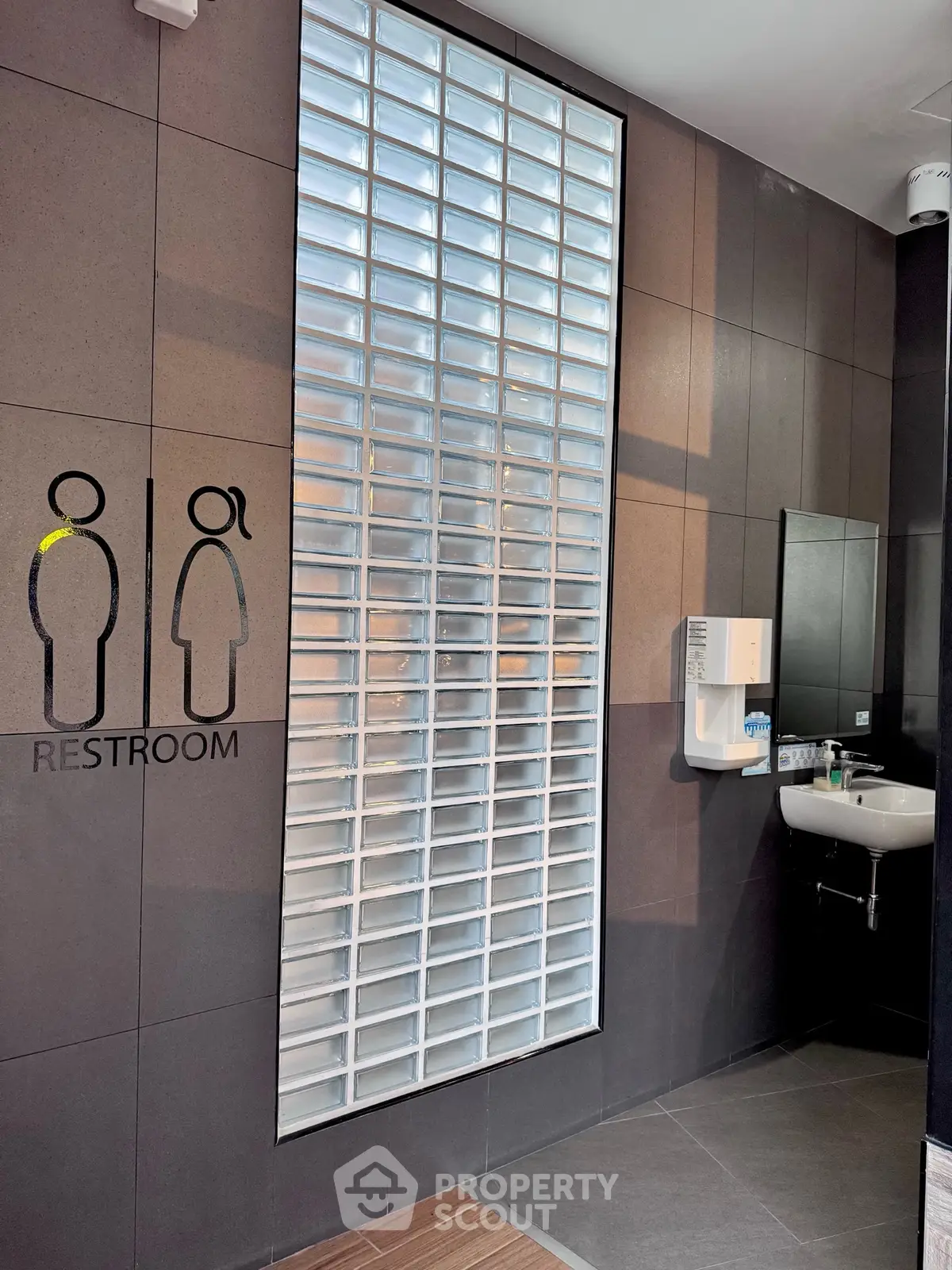 Modern restroom with sleek design and glass block wall for natural light.