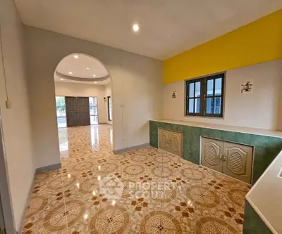 Spacious open-plan interior with unique tiled flooring and archway, perfect for modern living.