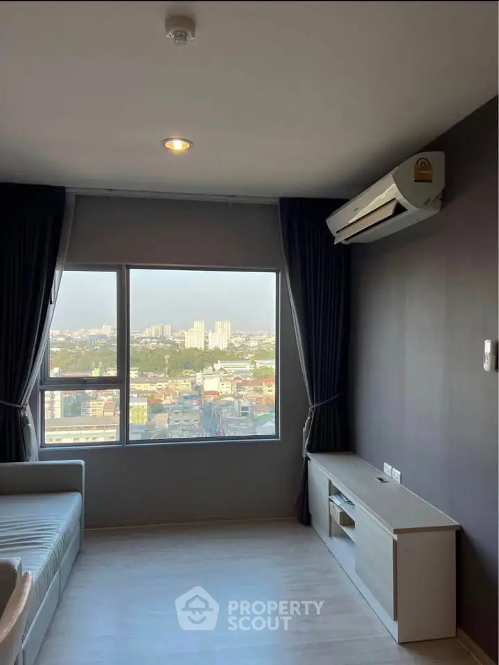 Modern living room with large window offering stunning city view and sleek air conditioning unit.