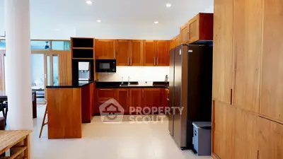 Spacious modern kitchen with wooden cabinets and stainless steel appliances