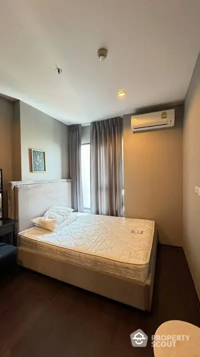 Modern bedroom with stylish decor and natural light in a cozy apartment.