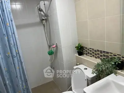 Modern bathroom with shower, toilet, and decorative plants for a fresh ambiance.