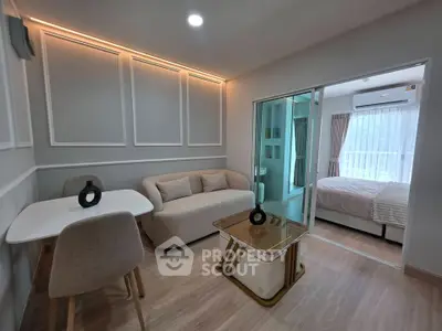 Modern living room with cozy sofa and dining area adjacent to a bright bedroom.