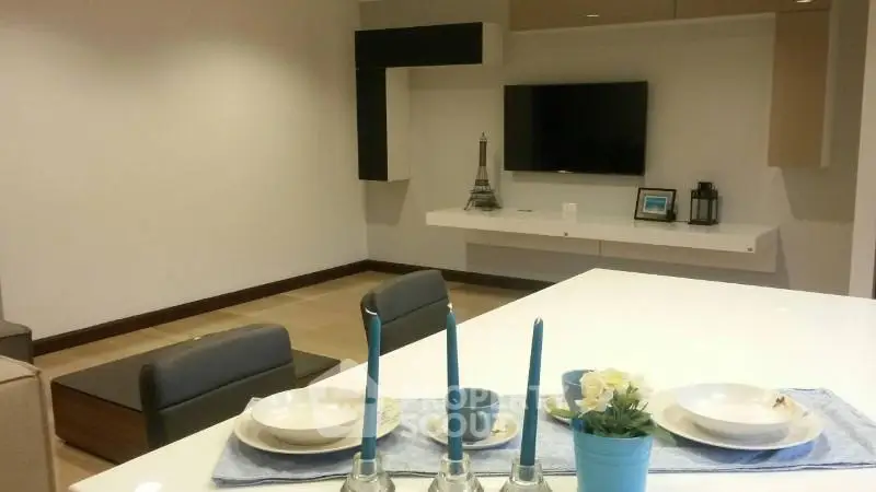 Modern living room with sleek TV setup and elegant dining area, perfect for contemporary living.