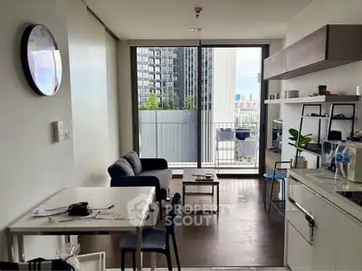 Modern living room with open kitchen and balcony view in urban apartment.