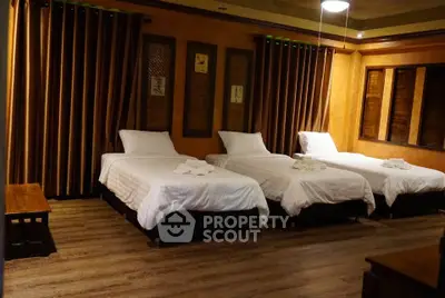 Spacious bedroom with three single beds and elegant wooden decor