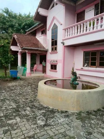 Charming pink two-story house with unique architectural design and spacious outdoor area.