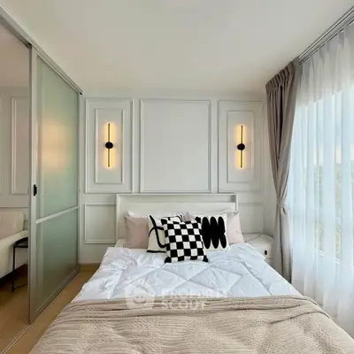 Modern bedroom with stylish decor and large window offering natural light and scenic views.