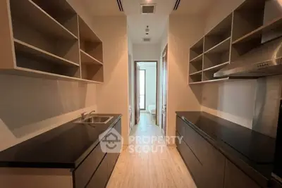 Sleek modern kitchen with open shelving and black countertops in a stylish apartment.