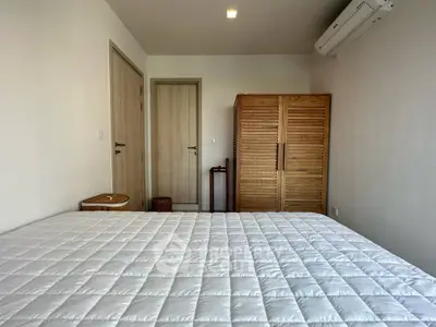 Cozy bedroom with wooden wardrobe and air conditioning, perfect for a comfortable living experience.