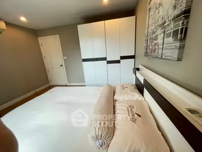 Spacious bedroom with modern wardrobe and cozy bedding in a stylish apartment.