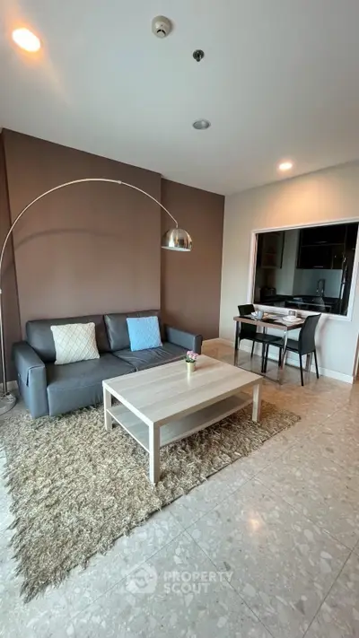 Spacious living room with modern decor and dining area in open layout apartment.