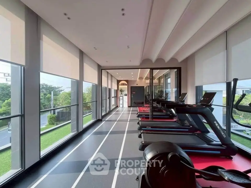 Modern gym with treadmills and large windows offering scenic views, perfect for fitness enthusiasts.