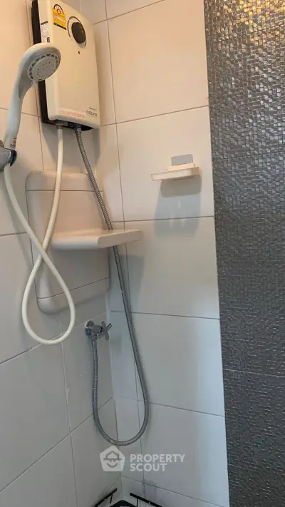 Modern bathroom with sleek shower and water heater, featuring stylish tile design.
