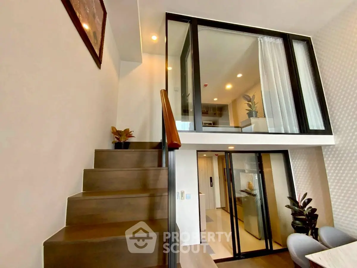Modern duplex apartment with stylish staircase and glass balcony, perfect for urban living.