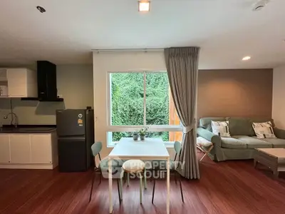 Spacious living room with modern kitchen and large window view