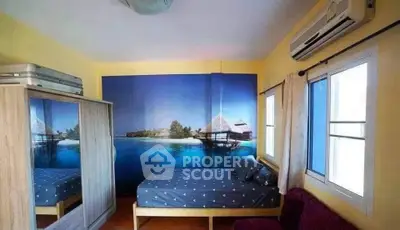 Cozy bedroom with tropical wall mural and modern air conditioning unit.