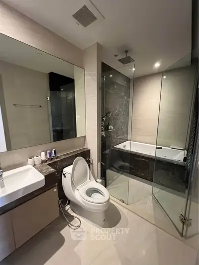 Luxurious modern bathroom with glass shower and bathtub in elegant apartment.
