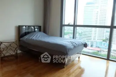 Spacious bedroom with city view and hardwood floors in modern apartment.