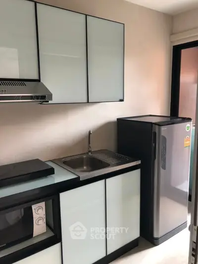 Modern compact kitchen with sleek appliances and minimalist design