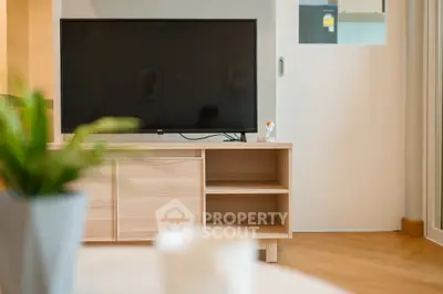 Modern living room with sleek TV setup and stylish wooden furniture.
