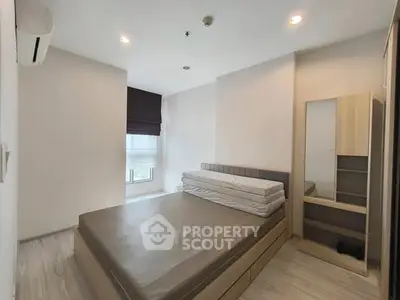 Modern minimalist bedroom with natural light and sleek furnishings.