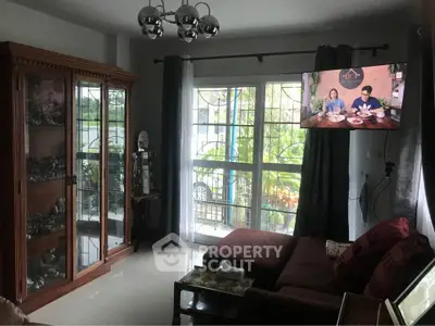 Cozy living room with large window and elegant wooden cabinet