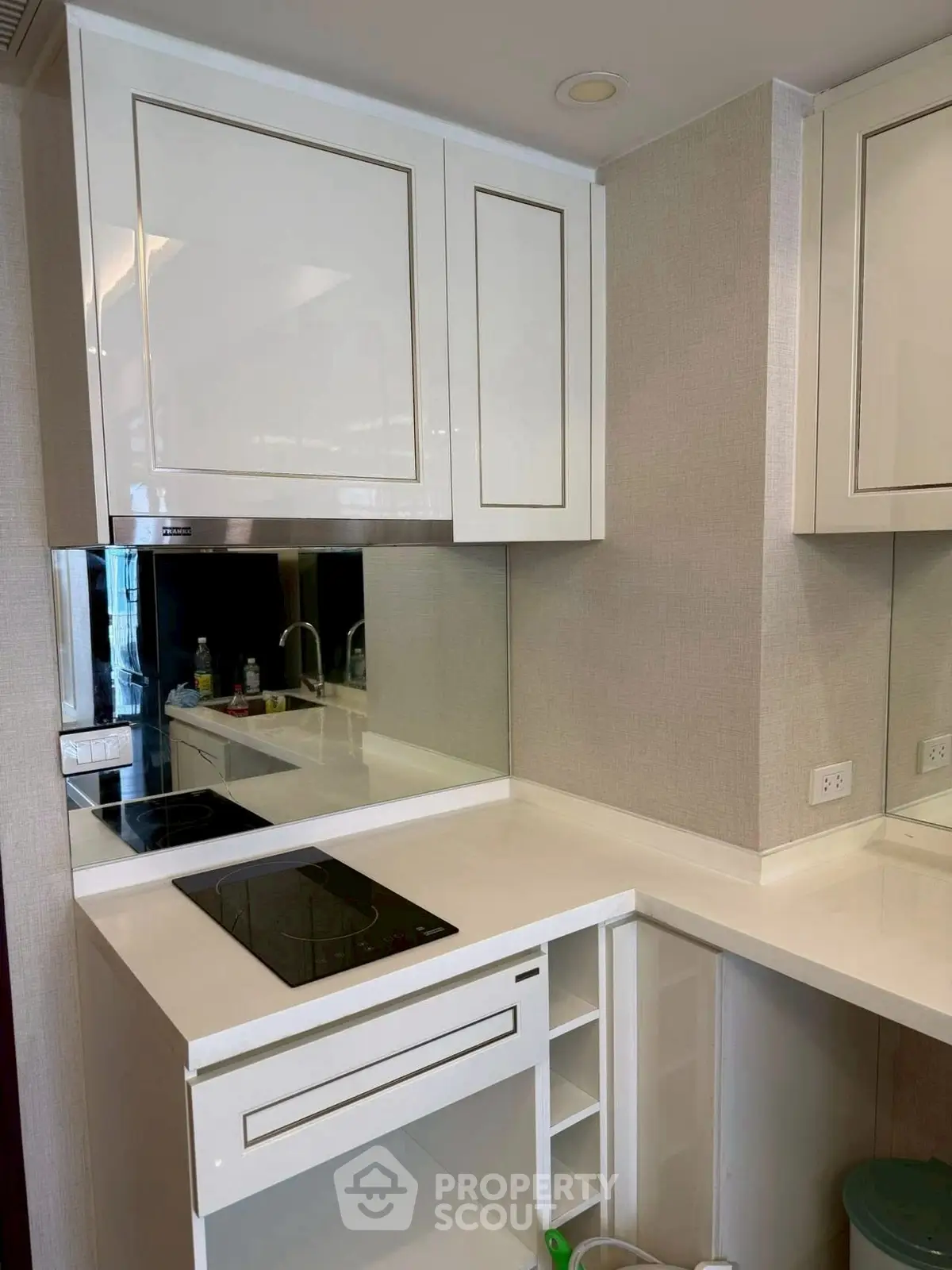 Modern kitchen with sleek white cabinets and electric cooktop