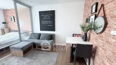 Modern living room with stylish decor and cozy seating area, featuring exposed brick walls and a compact workspace.