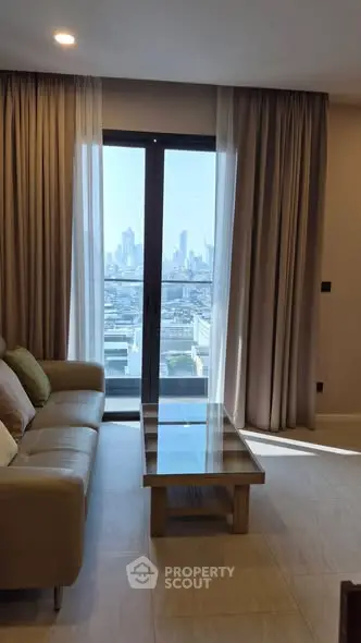 Stylish living room with city view from balcony, modern sofa and glass coffee table.