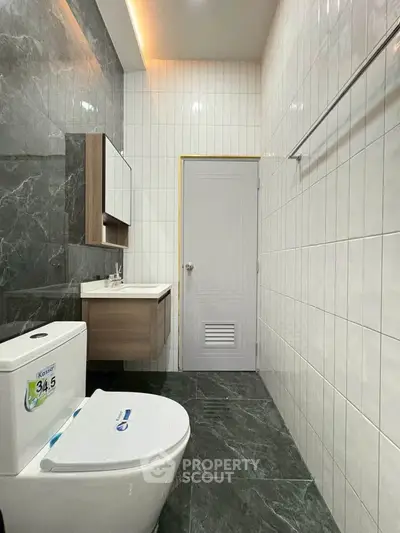 Modern bathroom with sleek design, featuring a stylish toilet and elegant wall tiles.