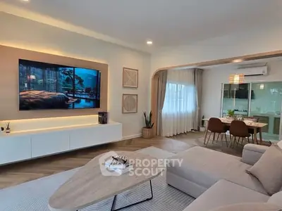 Modern living room with sleek furniture and open dining area, perfect for stylish living.