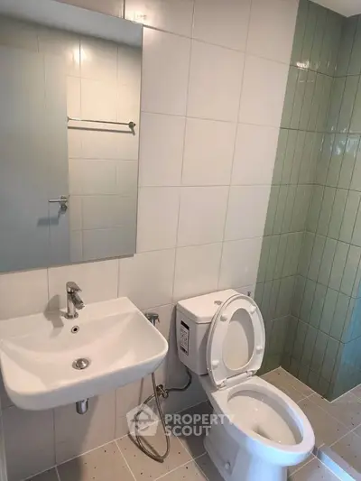 Modern bathroom with sleek fixtures and tiled walls in a contemporary apartment.
