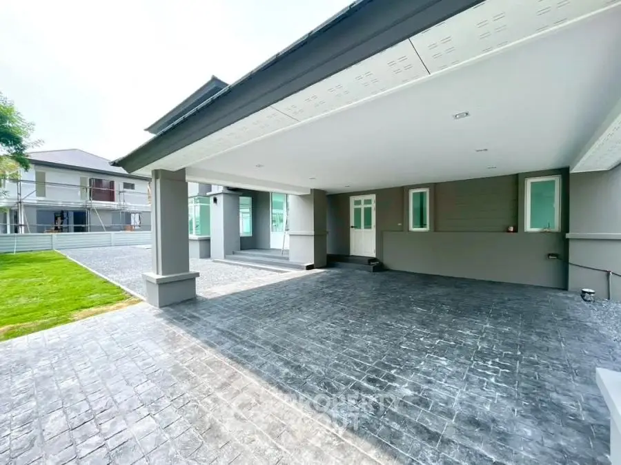 Spacious modern home exterior with large driveway and sleek design.