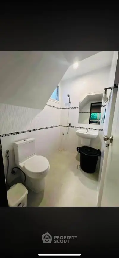 Modern bathroom with sleek design and efficient use of space, featuring a shower and toilet.