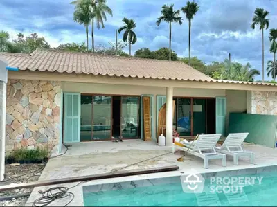 Charming tropical villa with pool and lush palm trees, perfect for serene living.