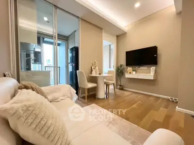 Modern living room with cozy seating and dining area, featuring sleek design and warm wooden flooring.