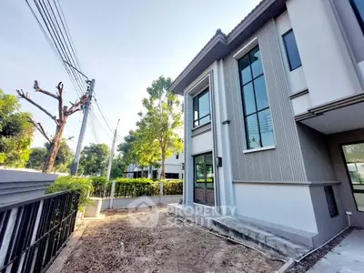 Modern two-story house exterior with large windows and landscaped garden
