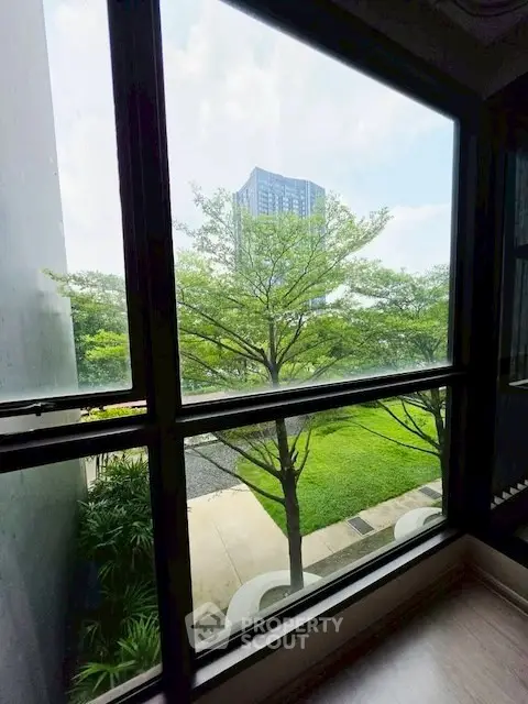 Scenic view from window overlooking lush greenery and modern building