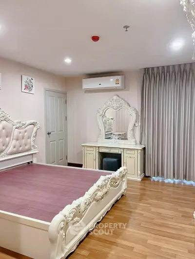 Elegant bedroom with ornate furniture and wooden flooring, featuring a classic vanity and luxurious bed frame.