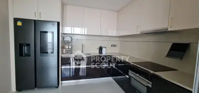 Modern kitchen with sleek black and white cabinetry, stainless steel appliances, and ample counter space.