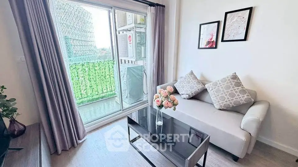 Charming living room with cozy sofa and balcony view, perfect for relaxation and entertaining.