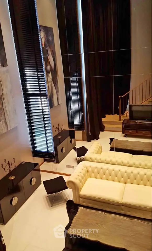 Luxurious living room with high ceilings, elegant decor, and modern furniture in a stylish apartment.